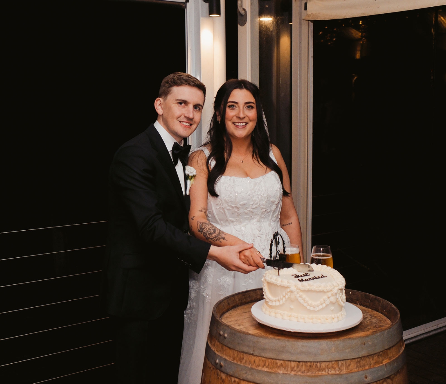 beach road winery wedding – alysha & nik 50 Alysha and Nik cut their white wedding cake together, standing beside a wooden wine barrel at Beach Road Winery.