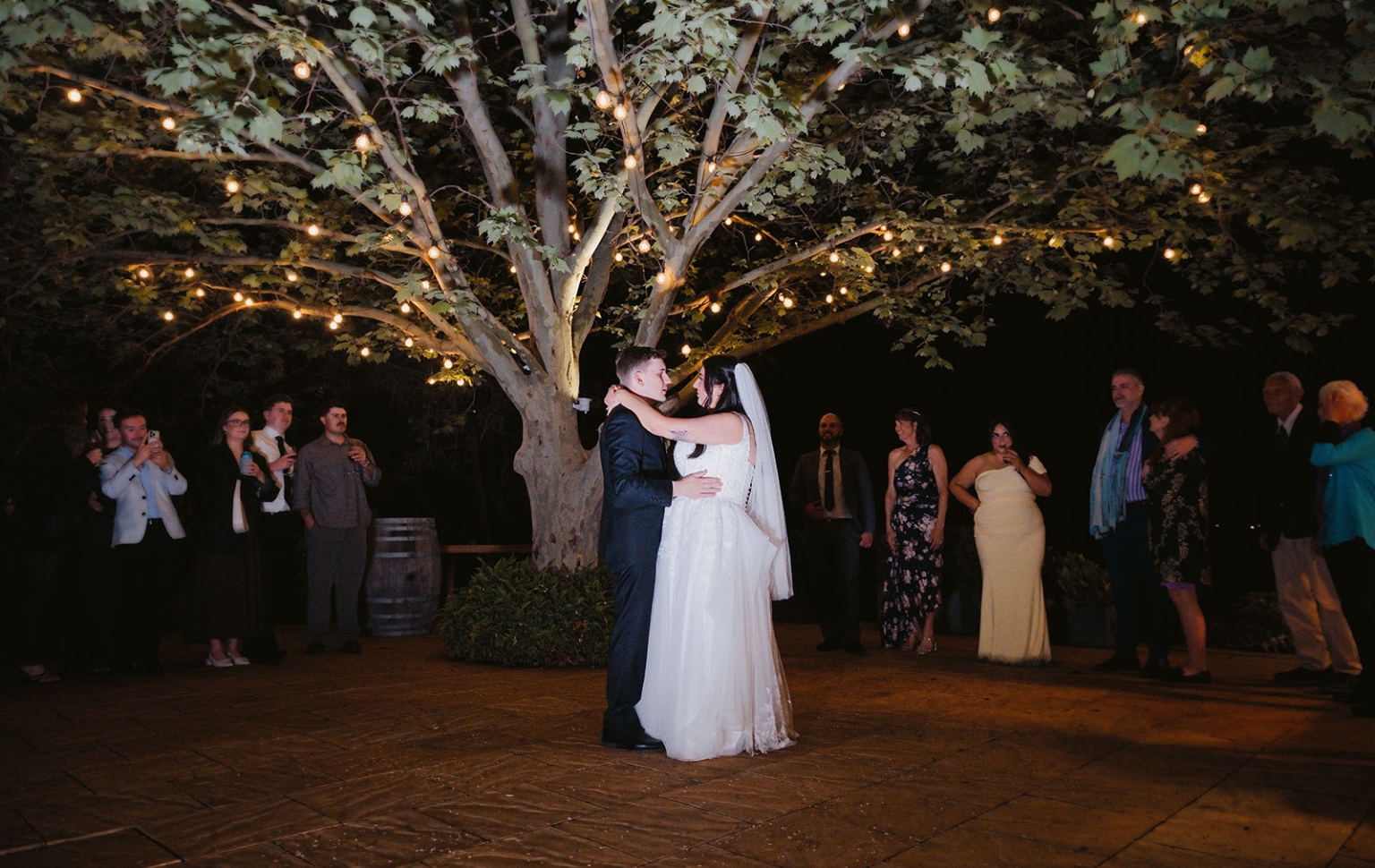 beach road winery wedding – alysha & nik 55 Alysha and Nik dancing beneath festoon lights in a tree as wedding guests watch at Beach Road Winery.