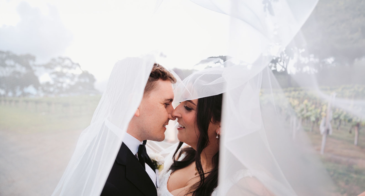 beach road winery wedding – alysha & nik 42 Alysha and Nik stand close together beneath Alysha’s wedding veil in a vineyard at Beach Road Winery.