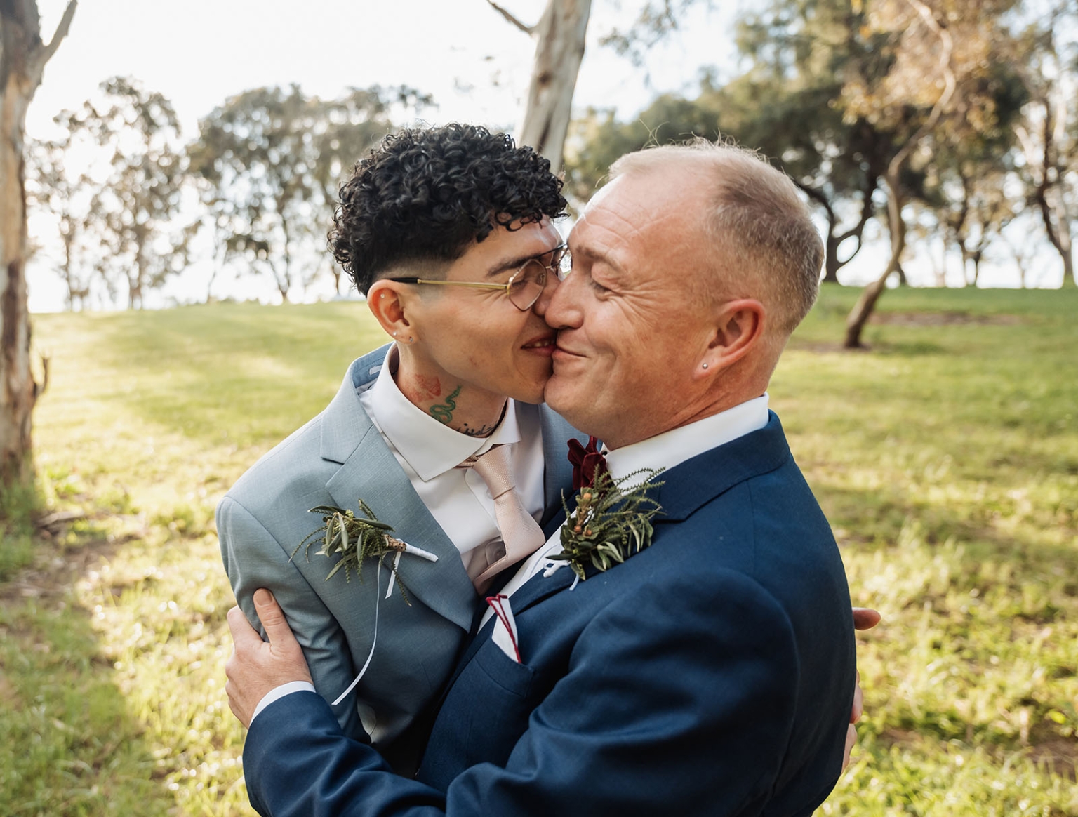 hotel royal wedding - brad & manuel 18 Brad and Manuel embracing in suits during their pre-wedding portrait session in a leafy park