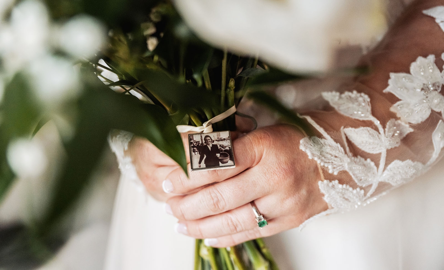 serafino winery wedding – maor & sasha 20 Bride in a lace-sleeved gown holding a white bouquet with a memorial photo charm and green gemstone ring