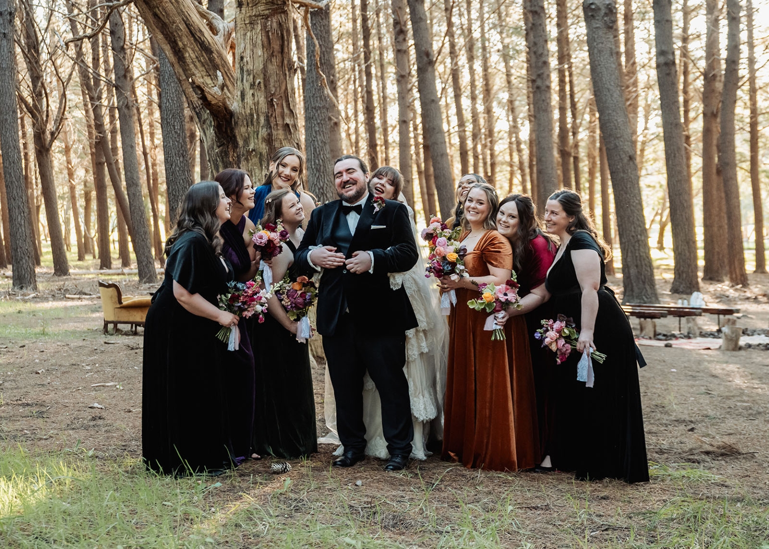 burbrook wedding – amber & angus | kuitpo forest wedding 36 Wedding party laughing around the groom in a sunlit forest, with bridesmaids holding colourful bouquets