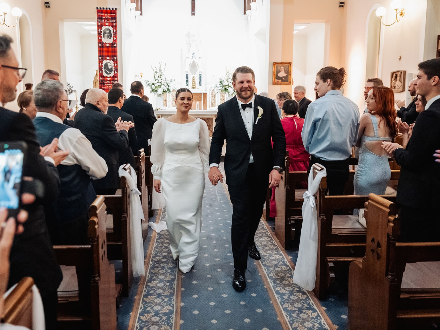 st joseph's chapel wedding – diana & michael 18 Diana and Michael walk hand in hand down the aisle as wedding guests applaud at St Joseph's Chapel in Kensington.