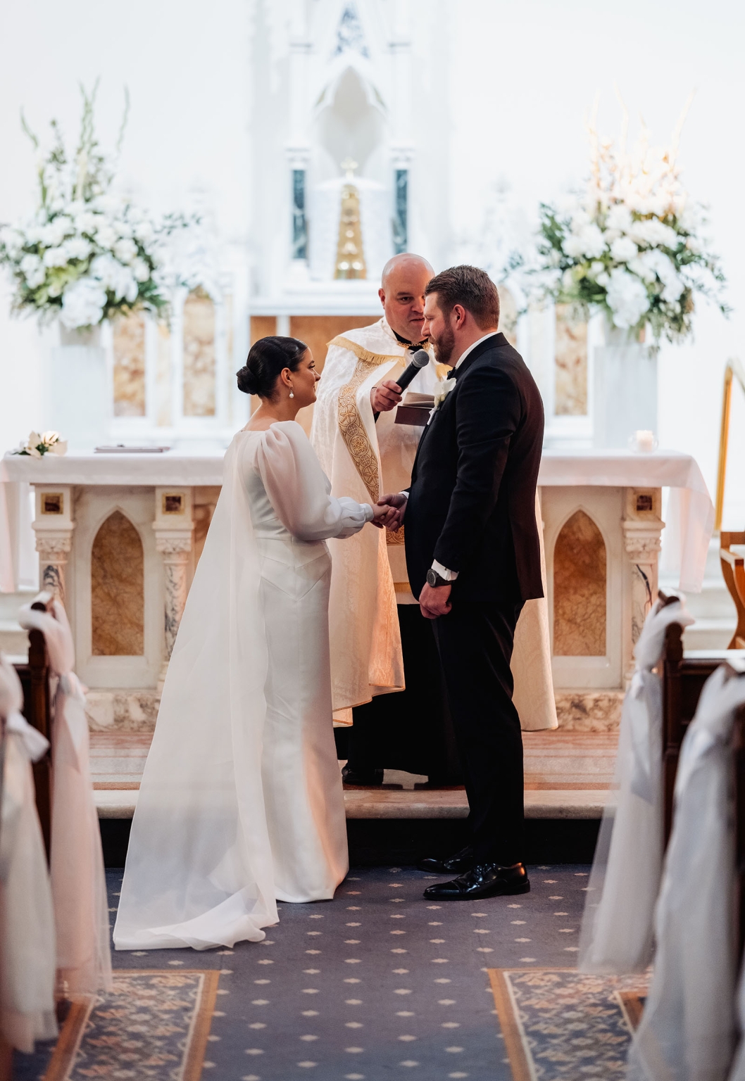 st joseph's chapel wedding – diana & michael 14 Diana and Michael holding hands as they exchange vows with their priest at St Joseph's Chapel