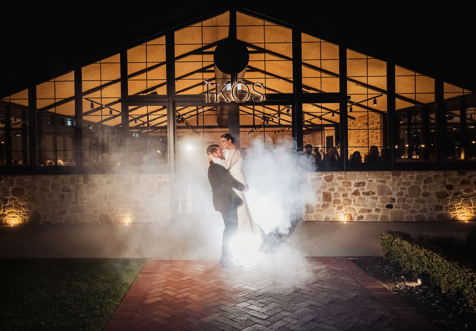 st joseph's chapel wedding – diana & michael 48 Diana and Michael embrace in illuminated fog outside IKOS during their wedding reception.