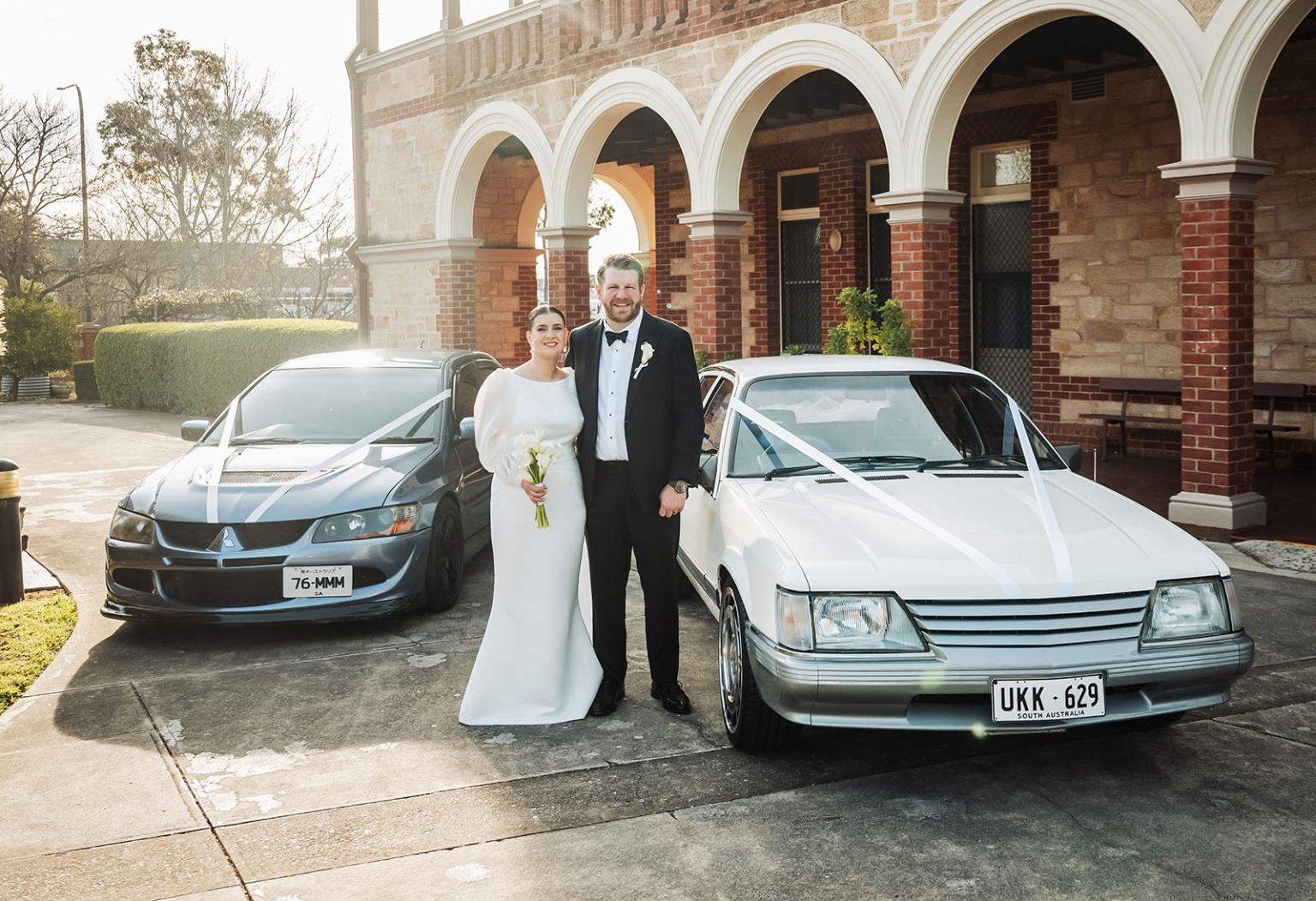 st joseph's chapel wedding – diana & michael 24 Diana and Michael standing between two ribbon-decorated cars outside St Joseph's Chapel in Kensington