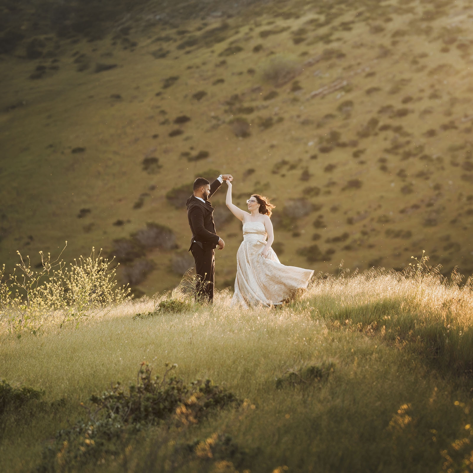 Ebony and Punit dancing together in a sunlit grassy field at Second Valley