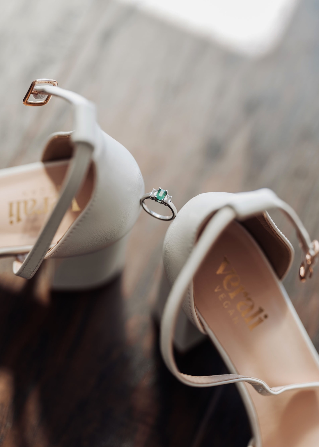 serafino winery wedding – maor & sasha 12 Emerald-cut green gemstone engagement ring resting between ivory bridal shoes