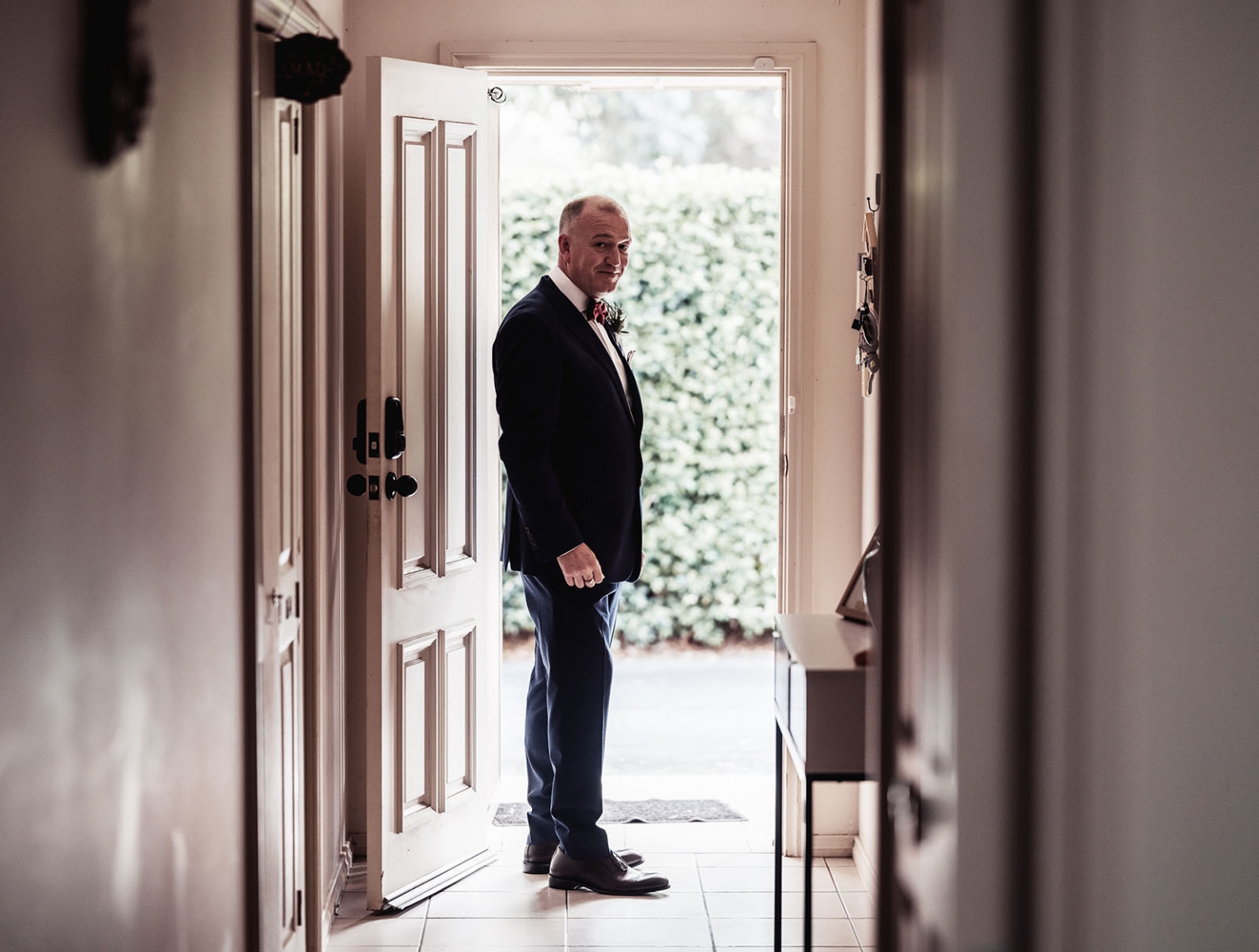 hotel royal wedding - brad & manuel 6 Groom in a dark suit standing in the open doorway of his home before the wedding