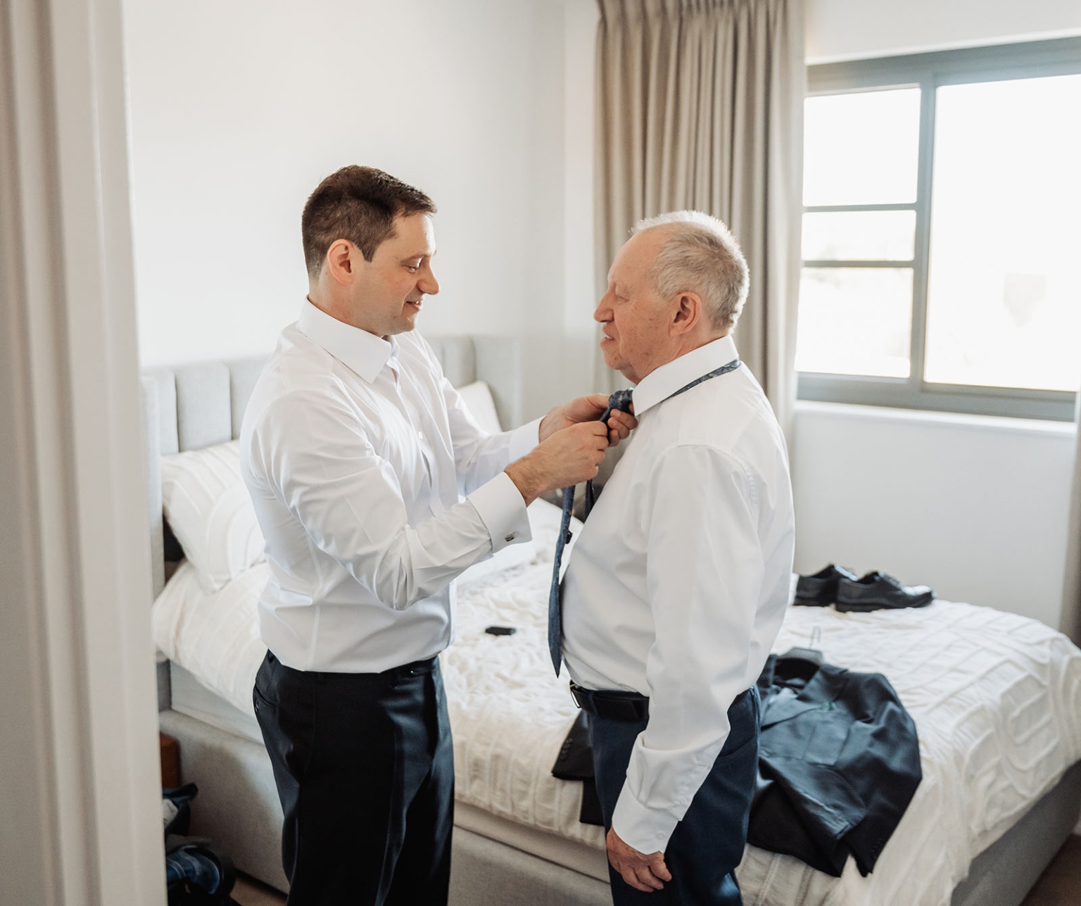 serafino winery wedding – maor & sasha 3 Maor helping an older man adjust his tie while they prepare for the wedding in a bedroom