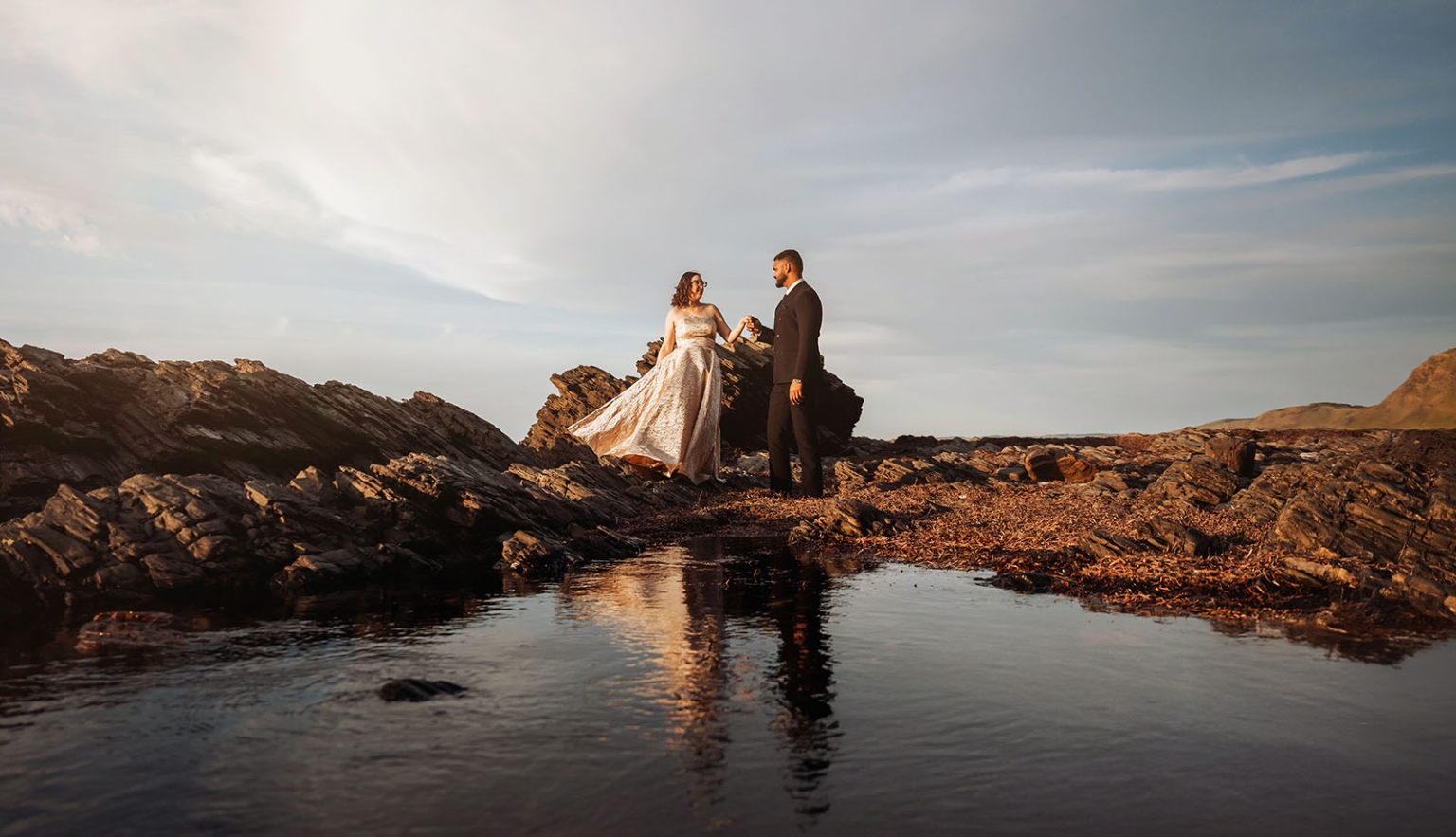 second valley wedding shoot - ebony & punit 8 Ebony and Punit holding hands on rocky shore beside a tidal pool at Second Valley