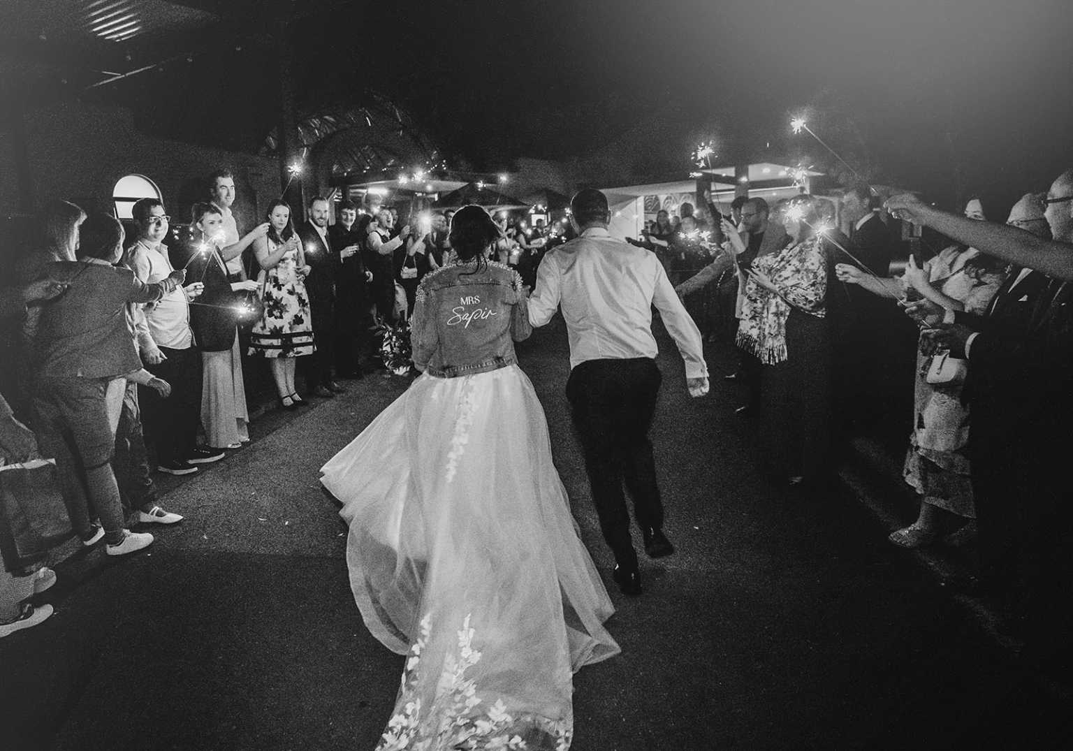 serafino winery wedding – maor & sasha 69 Newlyweds walk through guests holding sparklers during a nighttime wedding exit at Serafino Winery.
