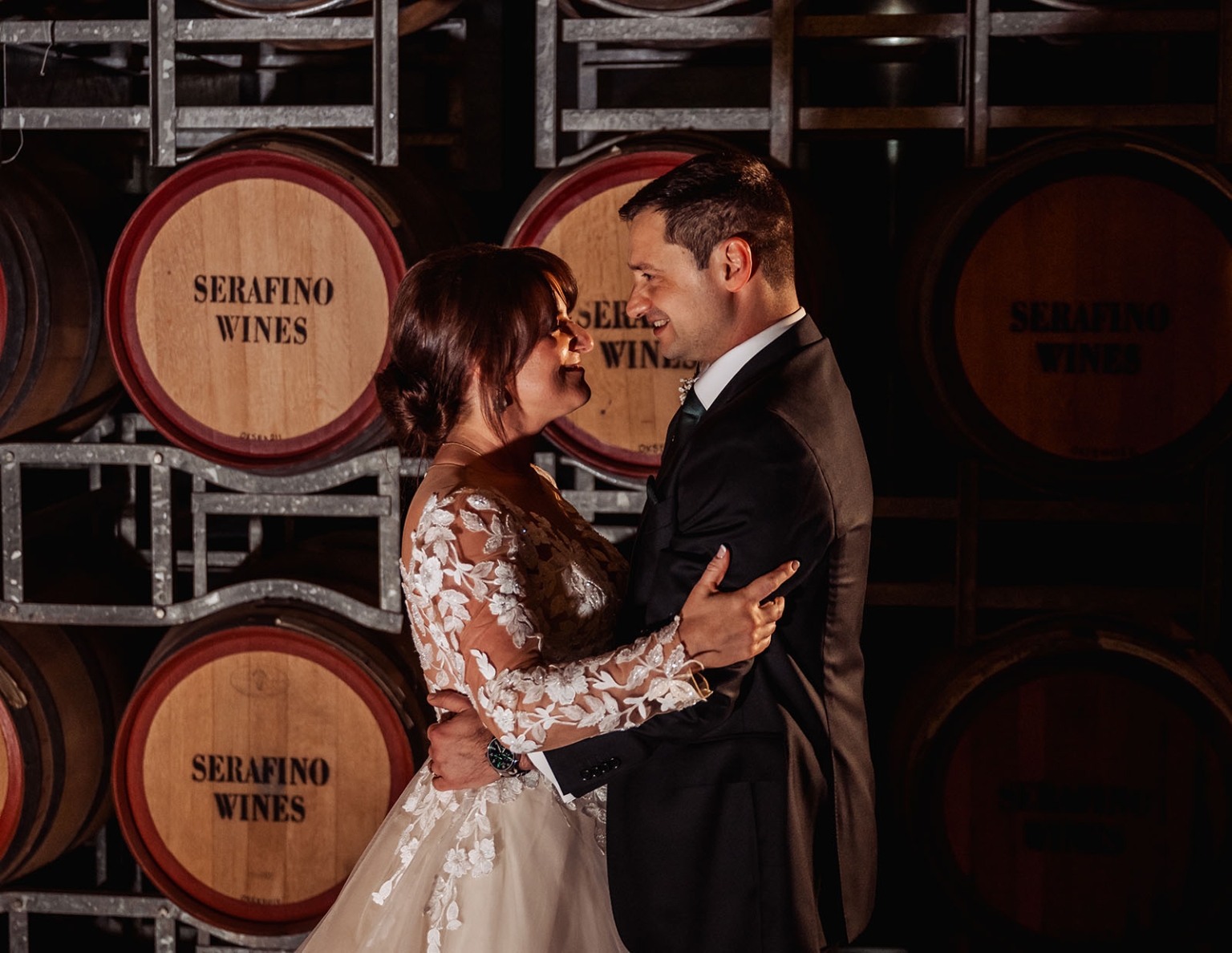 serafino winery wedding – maor & sasha 62 Bride and groom embracing beside Serafino Wines barrels at Serafino Winery