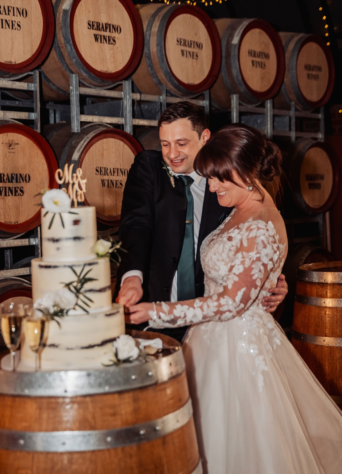 serafino winery wedding – maor & sasha 60 Bride and groom cutting their wedding cake beside Serafino Wines barrels