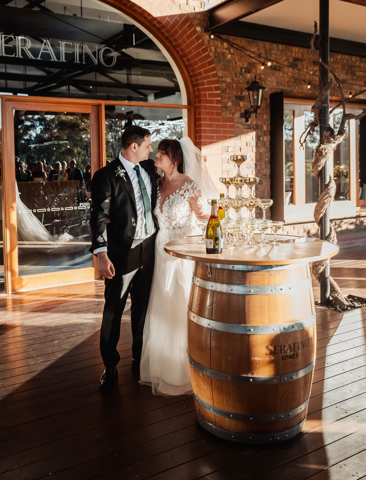 serafino winery wedding – maor & sasha 40 Bride and groom beside a champagne tower on a wine barrel at Serafino Winery
