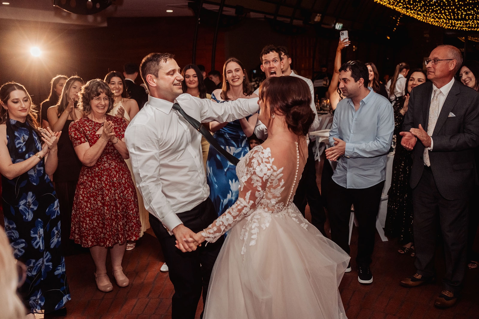 serafino winery wedding – maor & sasha 66 Bride and groom dancing together as wedding guests clap and cheer around them at Serafino Winery