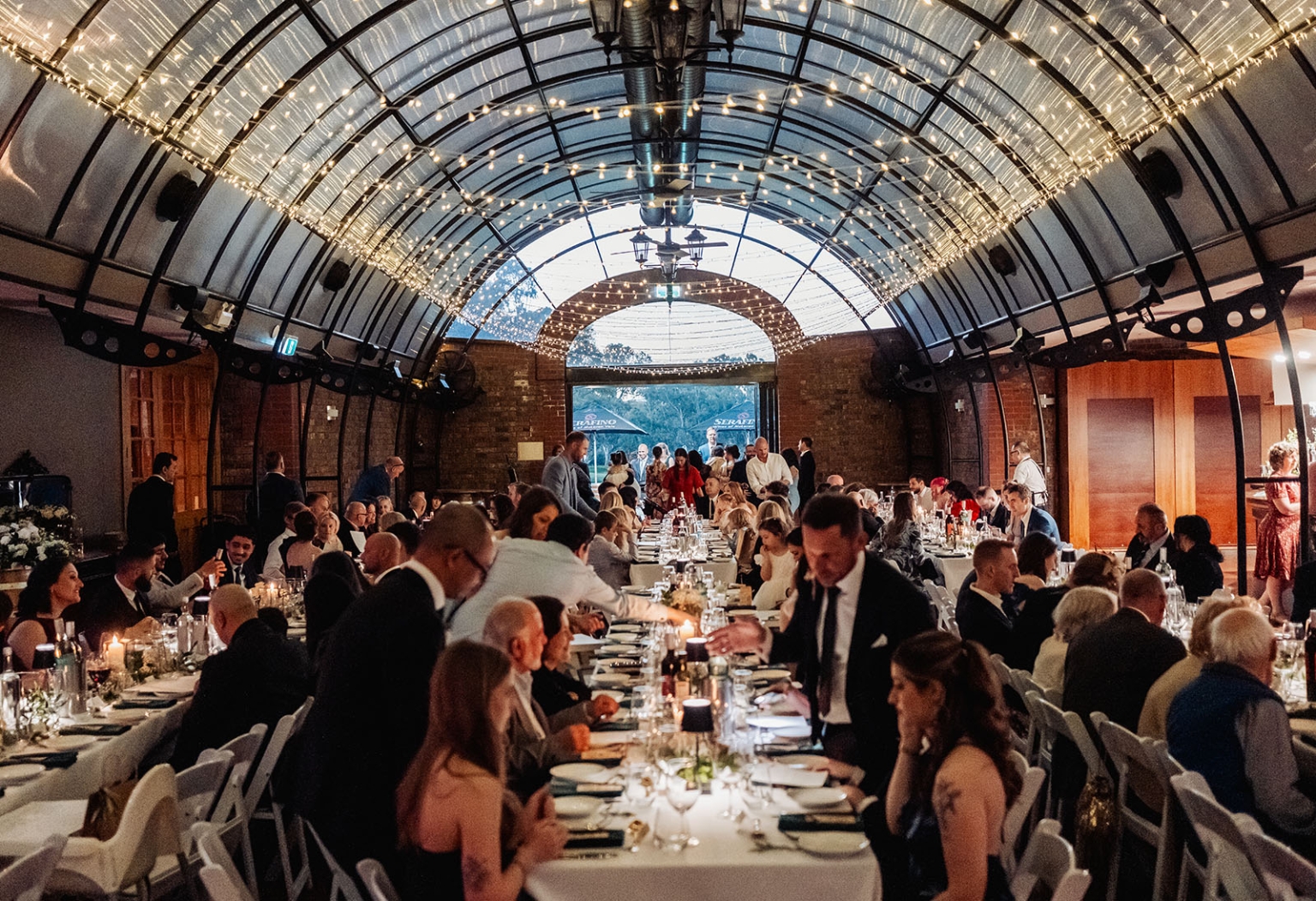 serafino winery wedding – maor & sasha 59 Wedding guests dining at long candlelit tables beneath fairy lights at Serafino Winery