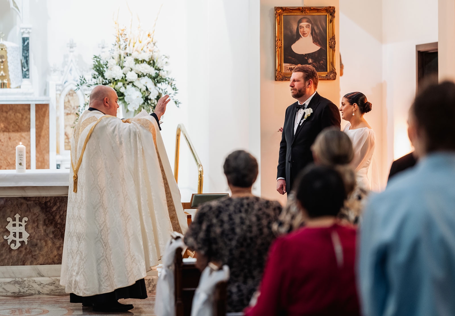 st joseph's chapel wedding – diana & michael 16 Priest blessing Diana and Michael during their wedding ceremony at St Joseph's Chapel, Kensington