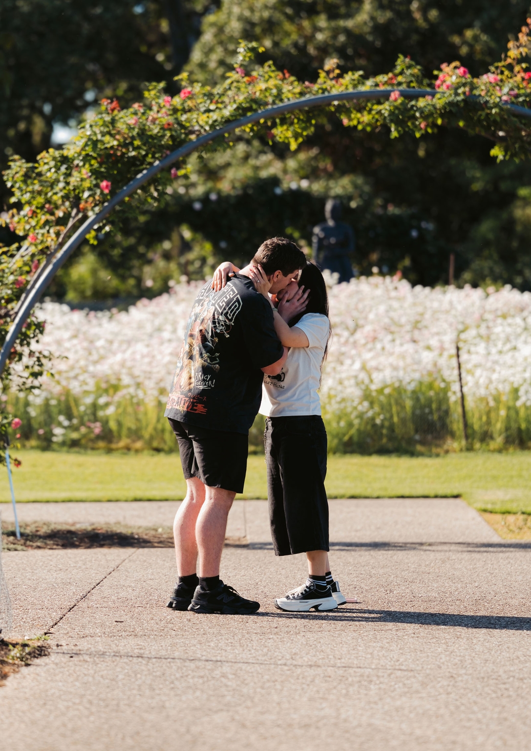 adelaide botanic gardens proposal – stewart & levi 2 Stewart and Levi kissing beneath a rose-covered arch at Adelaide Botanic Gardens