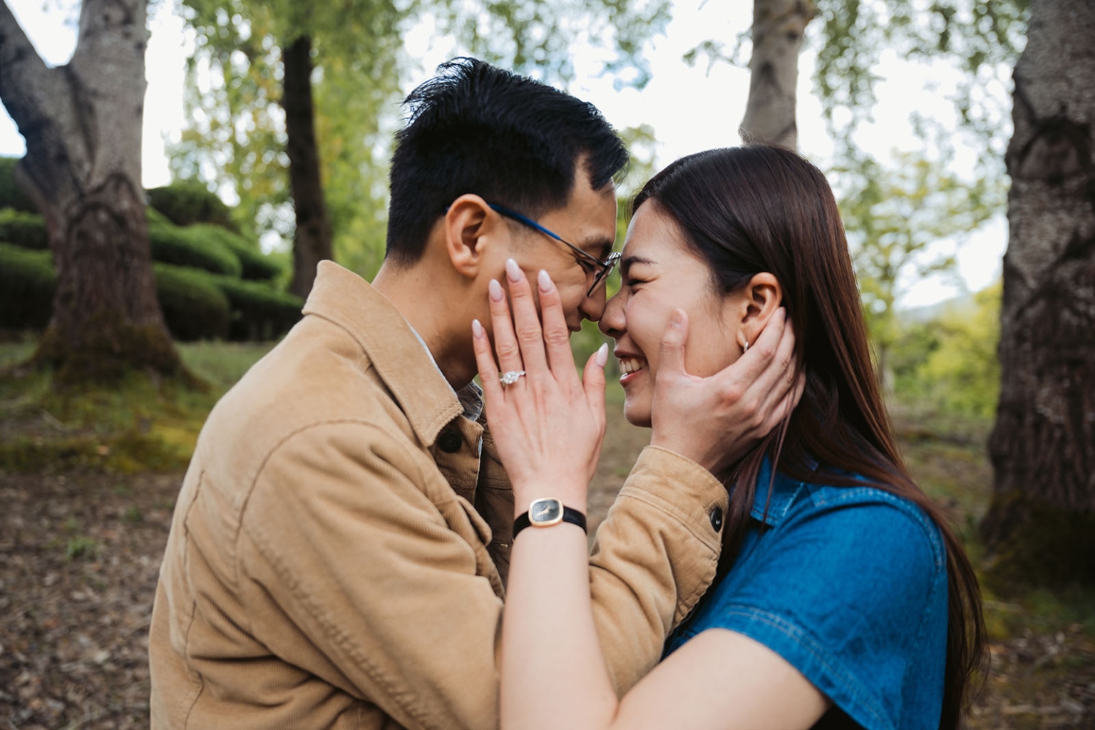 mt lofty botanic park proposal – watay & phouthun 21 Watay and Phouthun smiling forehead to forehead in Mount Lofty Botanic Garden, with Phouthun’s engagement ring visible.