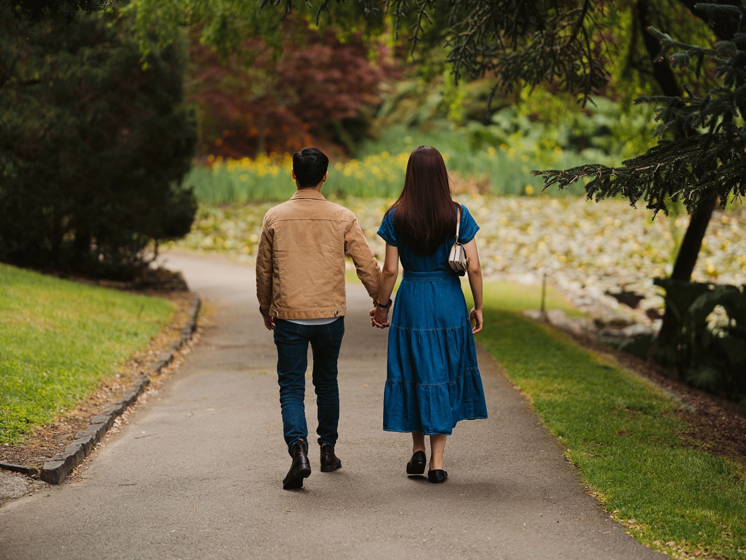 mt lofty botanic park proposal – watay & phouthun 11 Watay and Phouthun holding hands as they walk along a garden path at Mount Lofty Botanic Garden