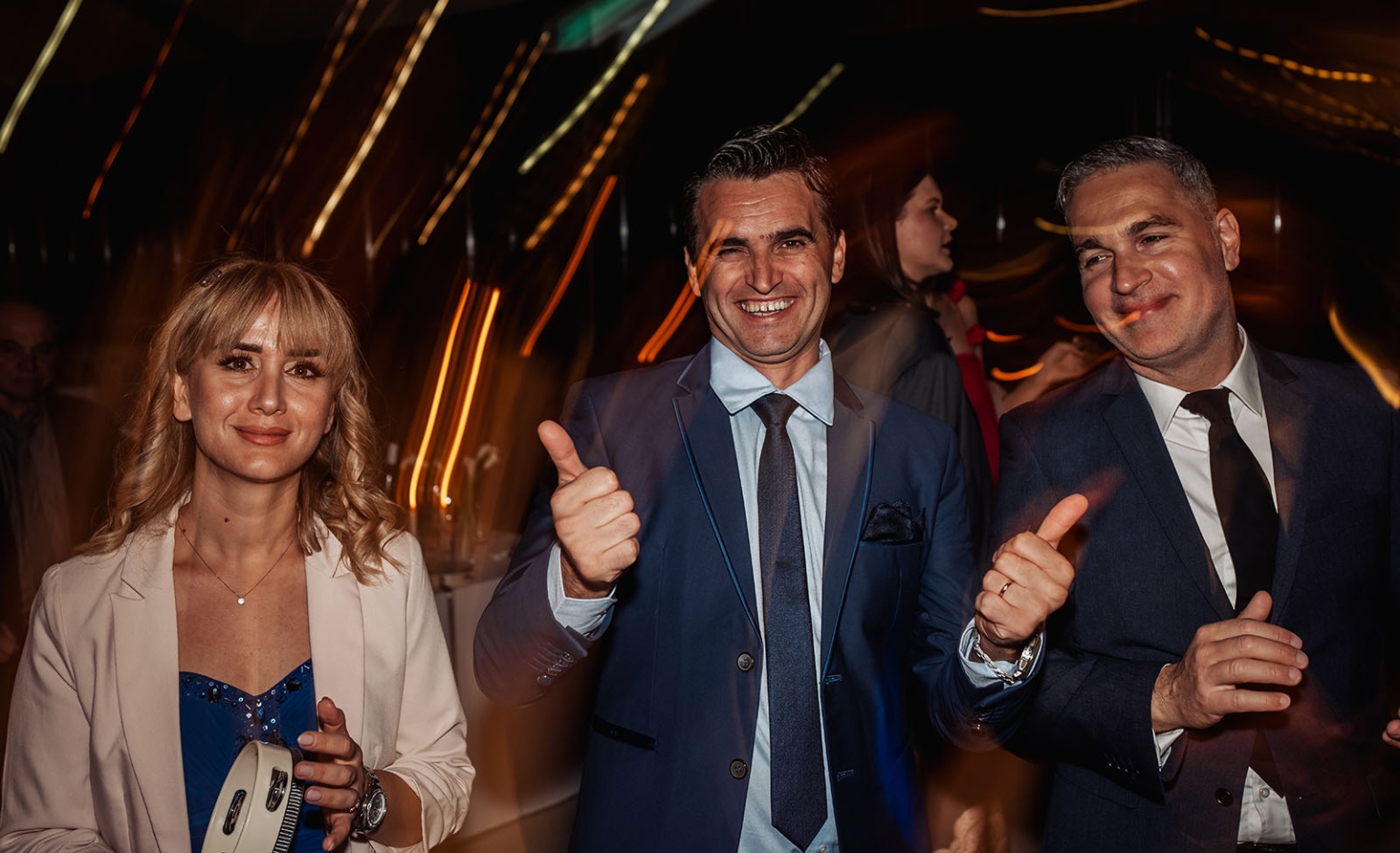st joseph's chapel wedding – diana & michael 51 Three wedding guests smiling and gesturing on a dimly lit dance floor