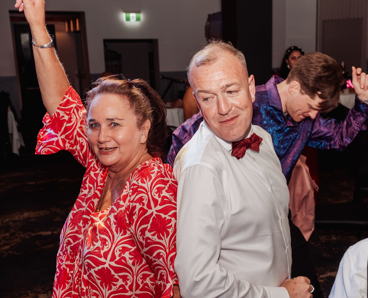 hotel royal wedding - brad & manuel 38 Wedding guests dancing at the Hotel Royal reception, with a woman raising her arm beside a man in a white shirt and red bow tie.