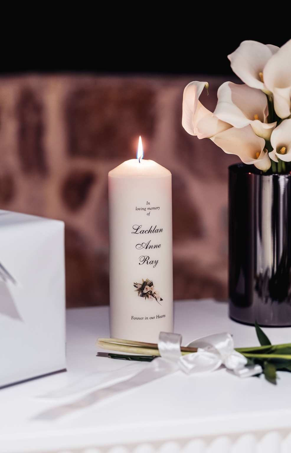 st joseph's chapel wedding – diana & michael 43 Lit memorial candle inscribed with names beside white calla lilies and ribbon at Diana and Michael's wedding