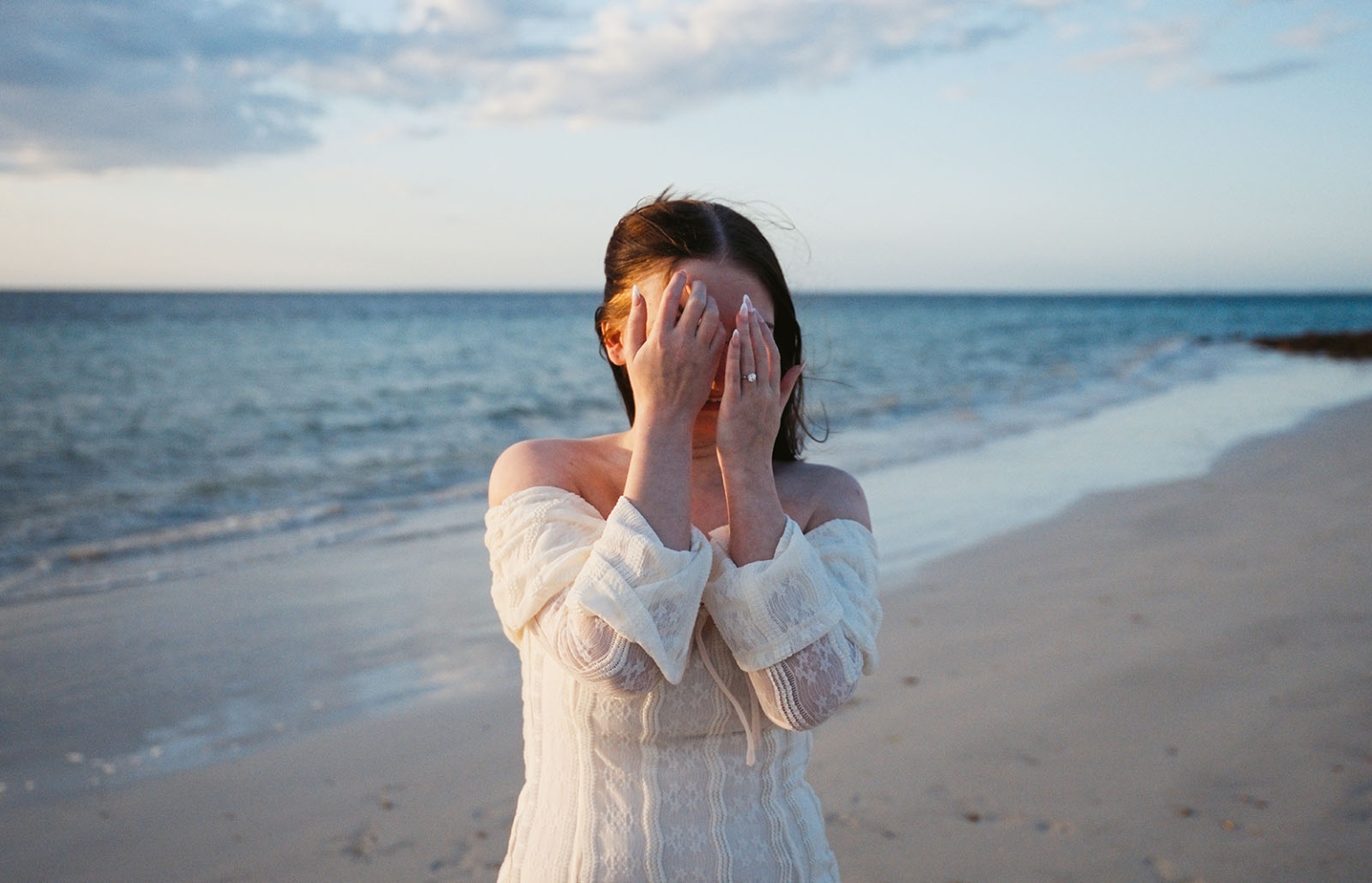moonta's simms cove proposal – zoe & nathan 3 Zoe covering her face with her hands to reveal her engagement ring on the beach at Simms Cove, Moonta