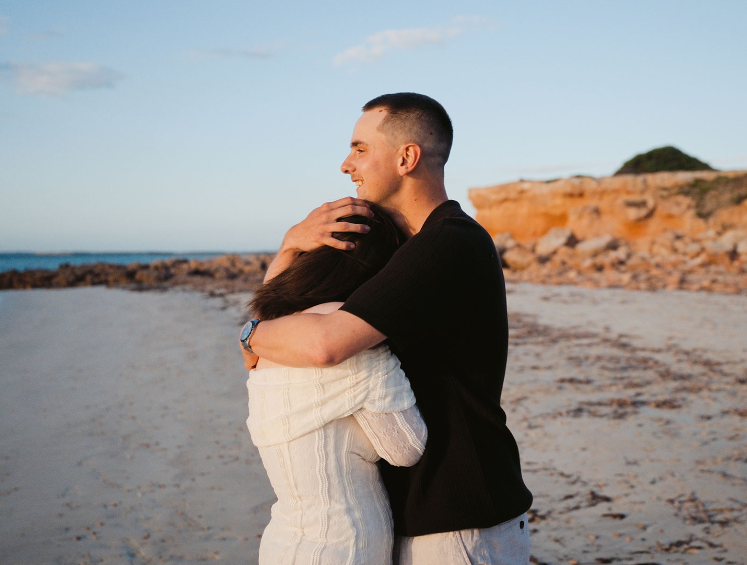 moonta's simms cove proposal – zoe & nathan 4 Nathan embraces Zoe on the sandy beach at Simms Cove, Moonta, after their proposal.
