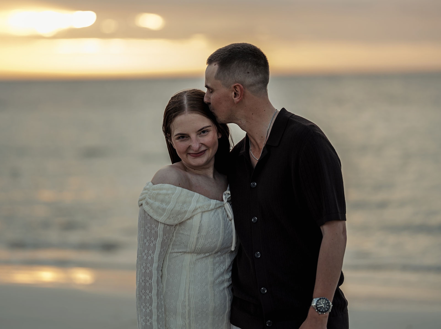 moonta's simms cove proposal – zoe & nathan 32 Nathan kisses Zoe on the forehead as they stand by the water at sunset at Simms Cove, Moonta.